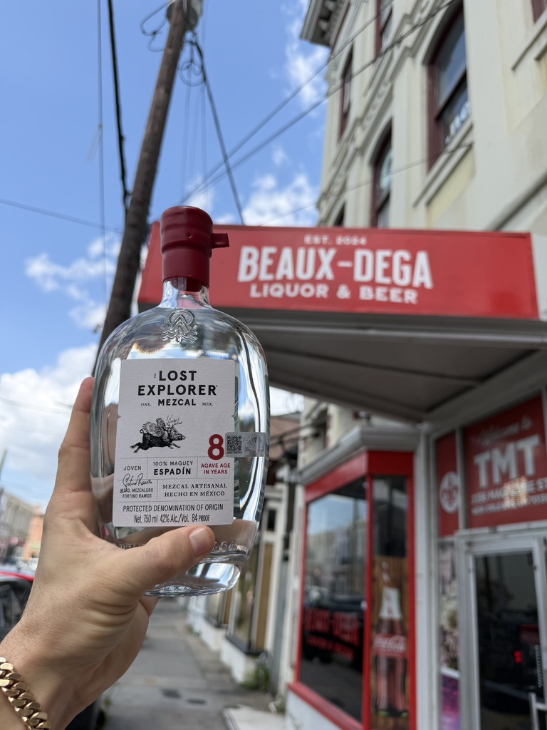 A bottle raised beneath the red Beaux-dega awning