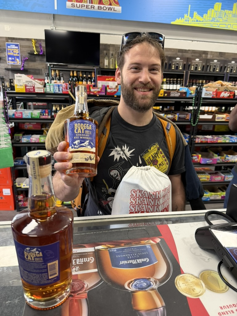 A customer with Bodega Cat whiskey at the store counter